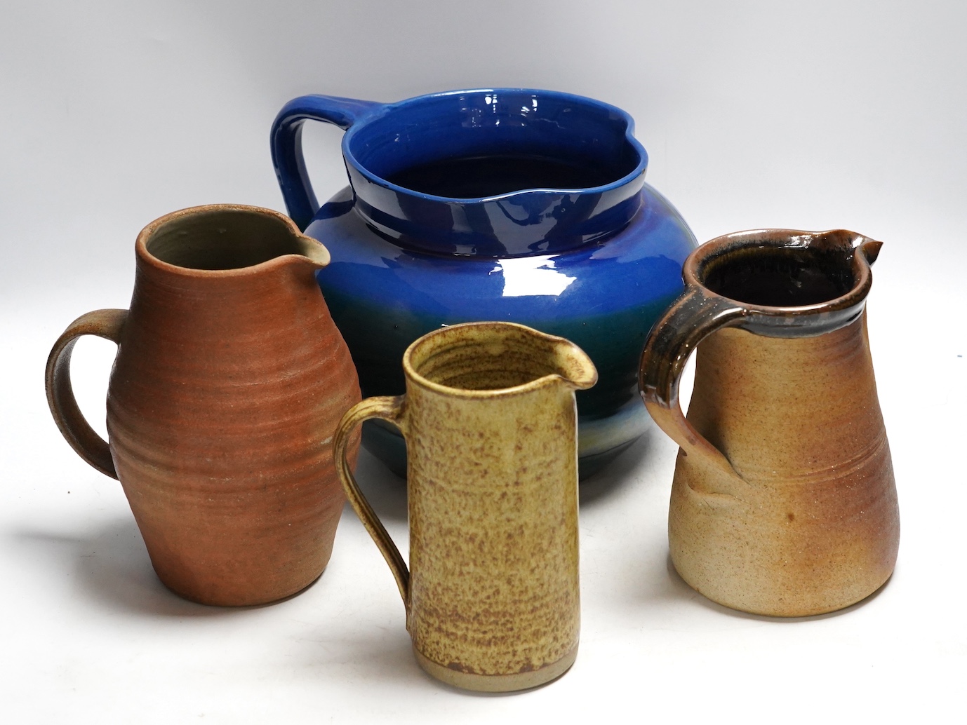 A group of six pottery jugs, to include GH Brannam, Muchelney and Bovey Tracey Art Pottery, largest 20cm high